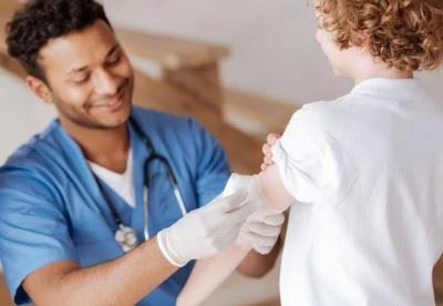 nurse wrapping wound on pediatric patient