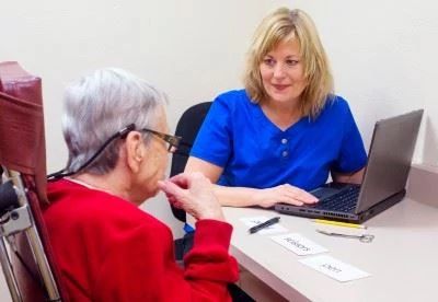 nurse on computer talking with patient