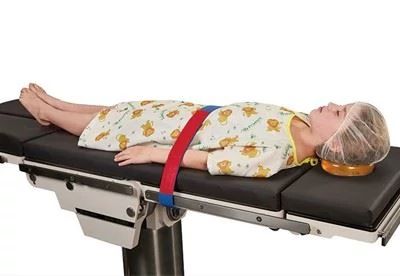 pediatric patient on operating table with safety straps and head positioner