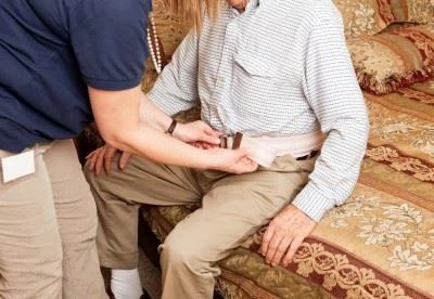 nurse putting gait belt on patient