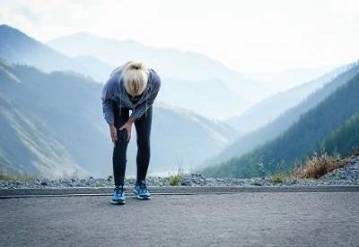 woman holding her knee after running