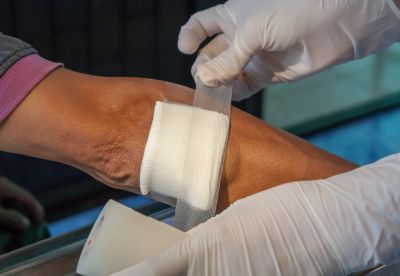 nurse putting gauze on wound on patient