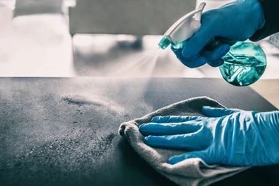 nurse spraying and wiping down surface