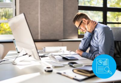 man sitting at desk holding his neck