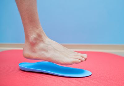 person hovering foot over insole