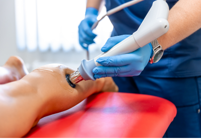 physical therapist using modality on a patient's leg