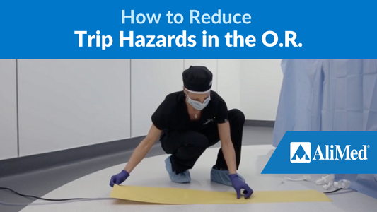 Medical staff putting floor strip over a cord. Text reads: How to reduce trip hazards in the O.R.  