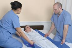 nurses transferring patient with patient shifter