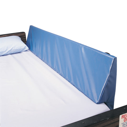 A bed features a SkiL-Care Bed Rail Wedge Pad in blue, placed against the side rail, with a white sheet and pillow.