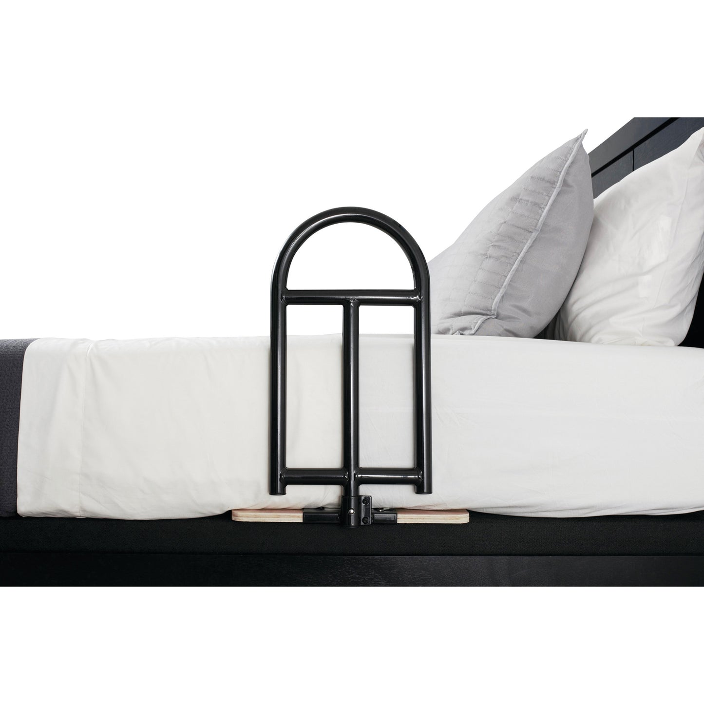 A Stander BedCane attached to the side of a bed with white sheets and gray pillows, providing support for a person getting in and out.