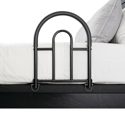 A black 'Bed Rail Advantage Traveler' is attached to a bed with white sheets and a gray pillow, offering safety and support.