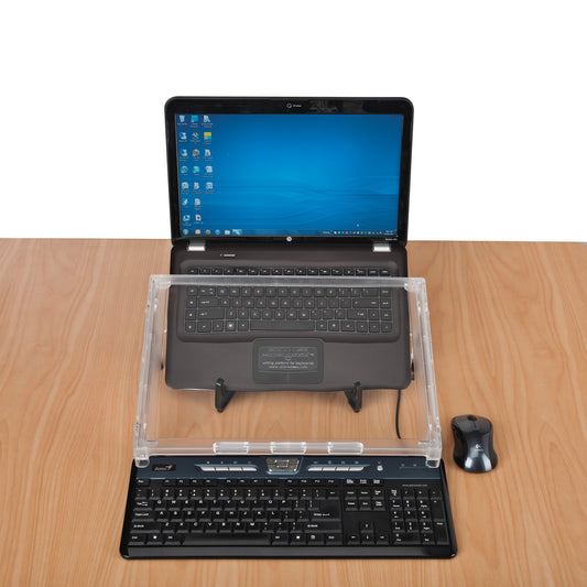 A Microdesk Compact Writing Platform sits on a wooden desk between a laptop and a keyboard, with a mouse beside it.