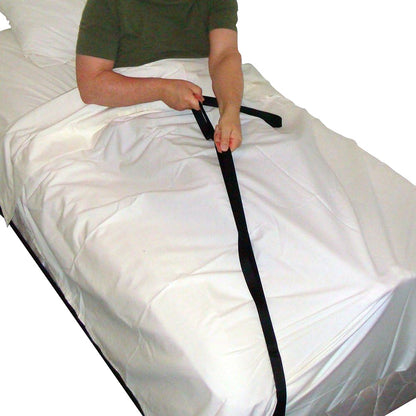 A person lying on a bed is using a SafetySure Economy Bed Pull-Up, a black strap aid, to sit up on white sheets.