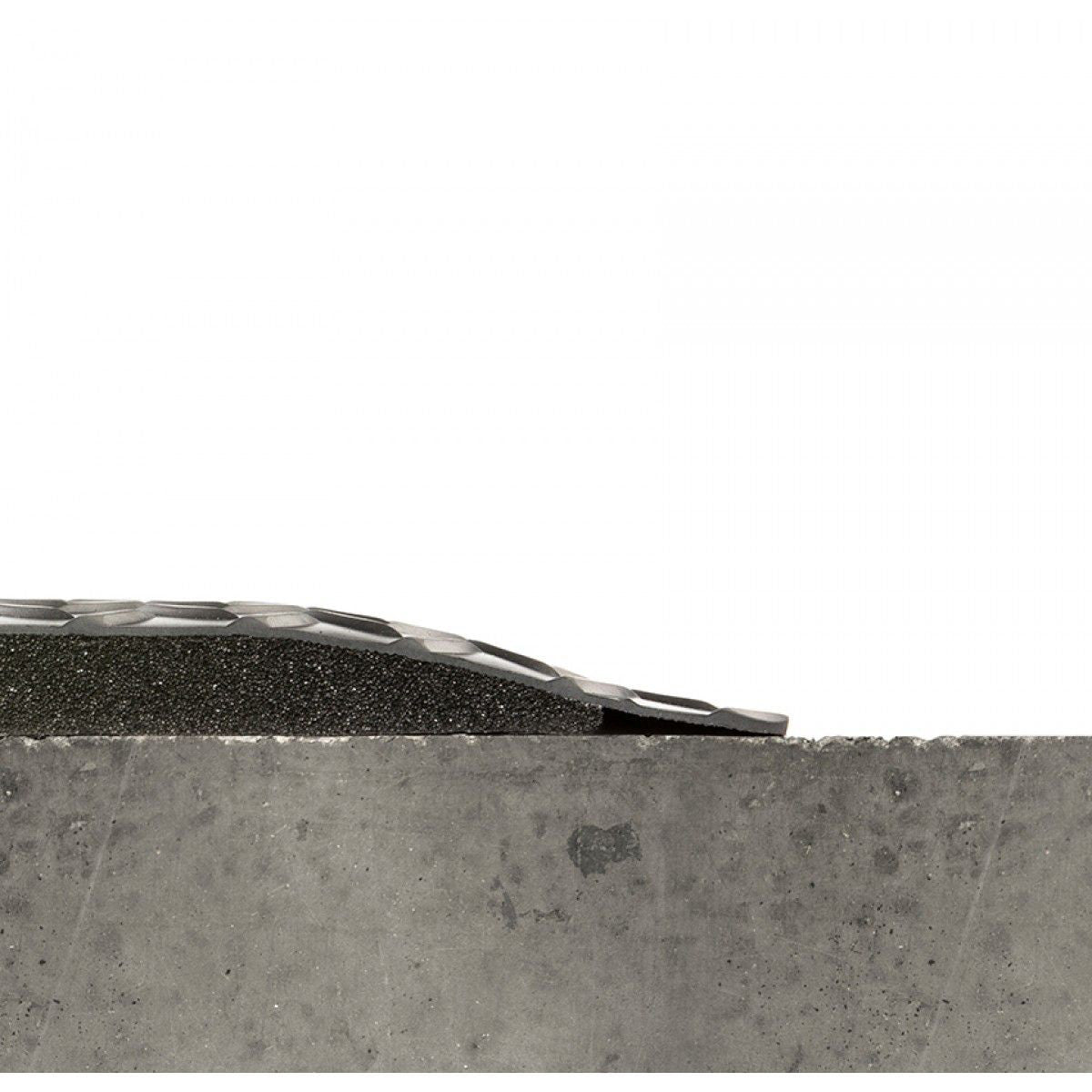 Side view of the Wearwell Electrically Conductive Anti-Fatigue Mat, showing layers of cushioning material on a flat surface.