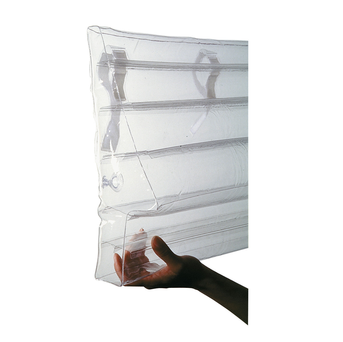 A person holds an AliMed Clear Inflatable Bed Bolster, shown as a transparent, rectangular inflatable cushion.
