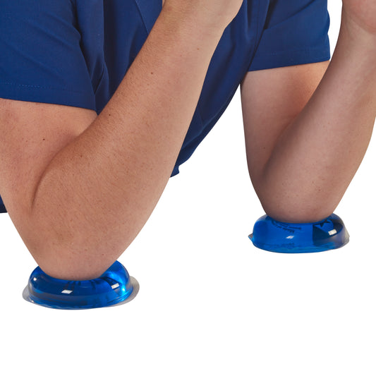 Person's elbows resting on AliMed AliBlue Gel Ulnar Nerve Pads, blue gel cushions designed to protect the ulnar nerve.
