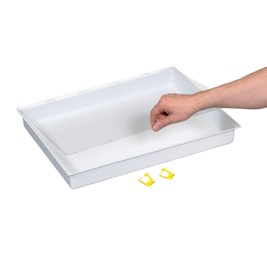 A hand reaches over a white AliMed Cart Accessory: Full Drawer Tray with Clear Lid and Lock, with yellow clips nearby.