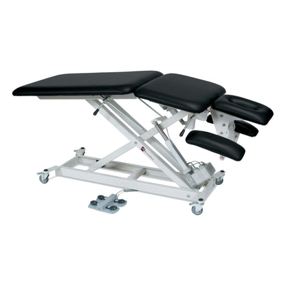 The Armedica AM-SX5000 Treatment Table is adjustable, with cushioned black sections and a white metal frame on wheels.
