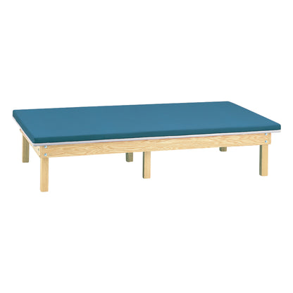 Clinton Bariatric Upholstered Mat Platform featuring a flat, cushioned blue surface on a sturdy wooden frame with multiple legs.