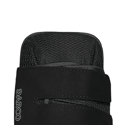 Close-up of the top of a black DARCO HeelWedge Healing Shoe, featuring a textured fabric and a strap with the brand logo visible.