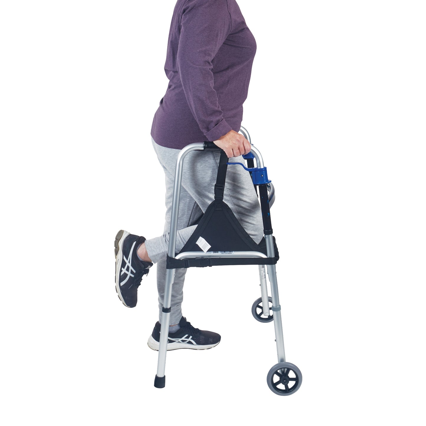 A person using a walker with their knee supported by the SafetySure The Knee Sling, wearing a purple top, gray pants, and black sneakers.