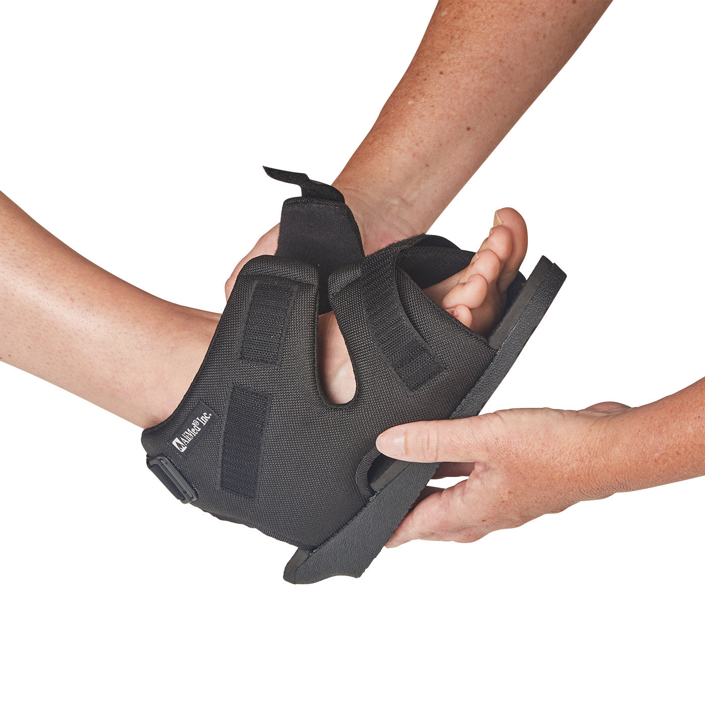 A person fits an AliMed Open Heel Orthosis on another's foot. It has black straps and an open heel with a flat, sturdy sole.