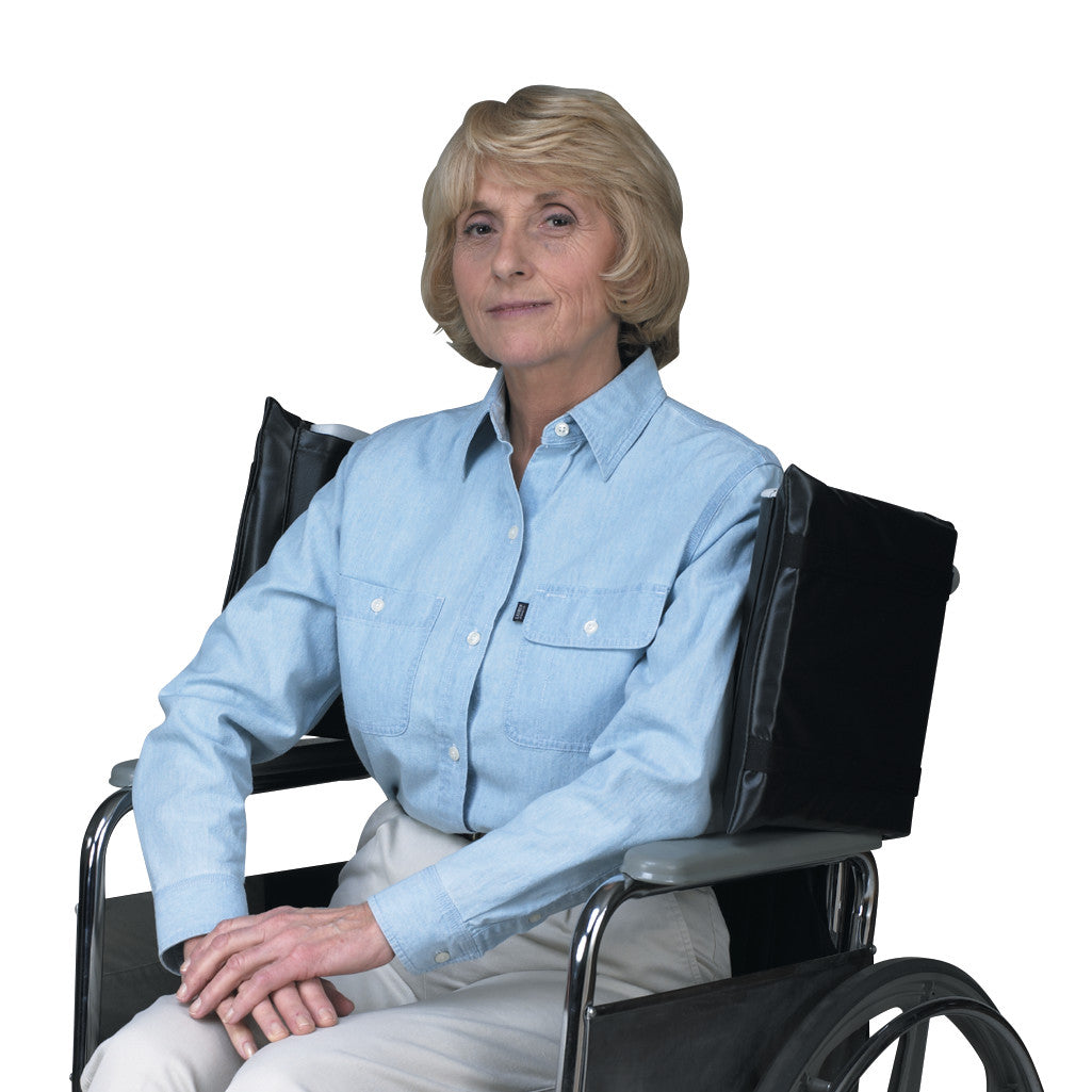 An elderly woman sits in a wheelchair equipped with SkiL-Care Standard Wheelchair Side Wings, providing support and comfort.