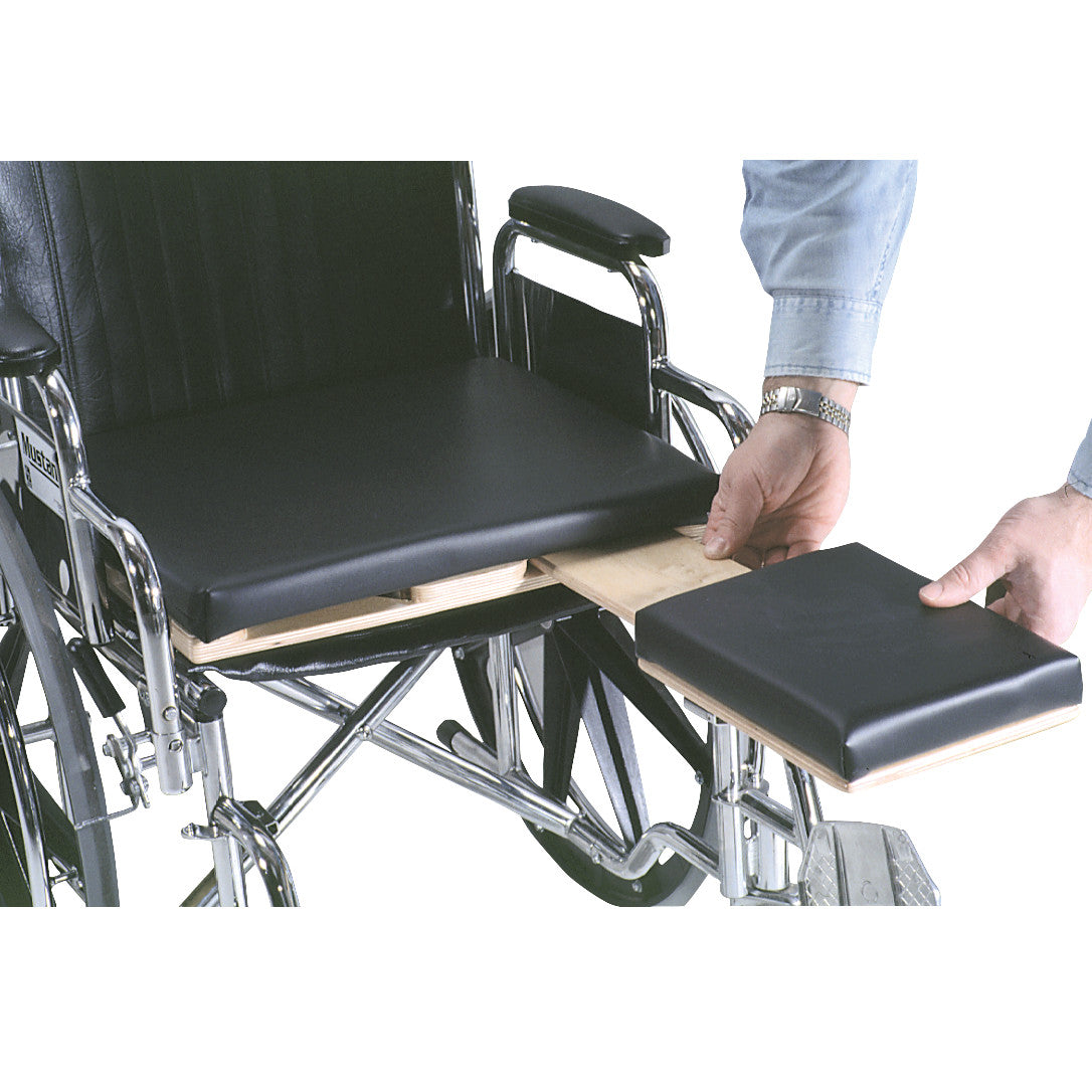 A person adjusts the AliMed Universal Amputee Seat on a wheelchair. The seat has a removable black cushion and wooden support.