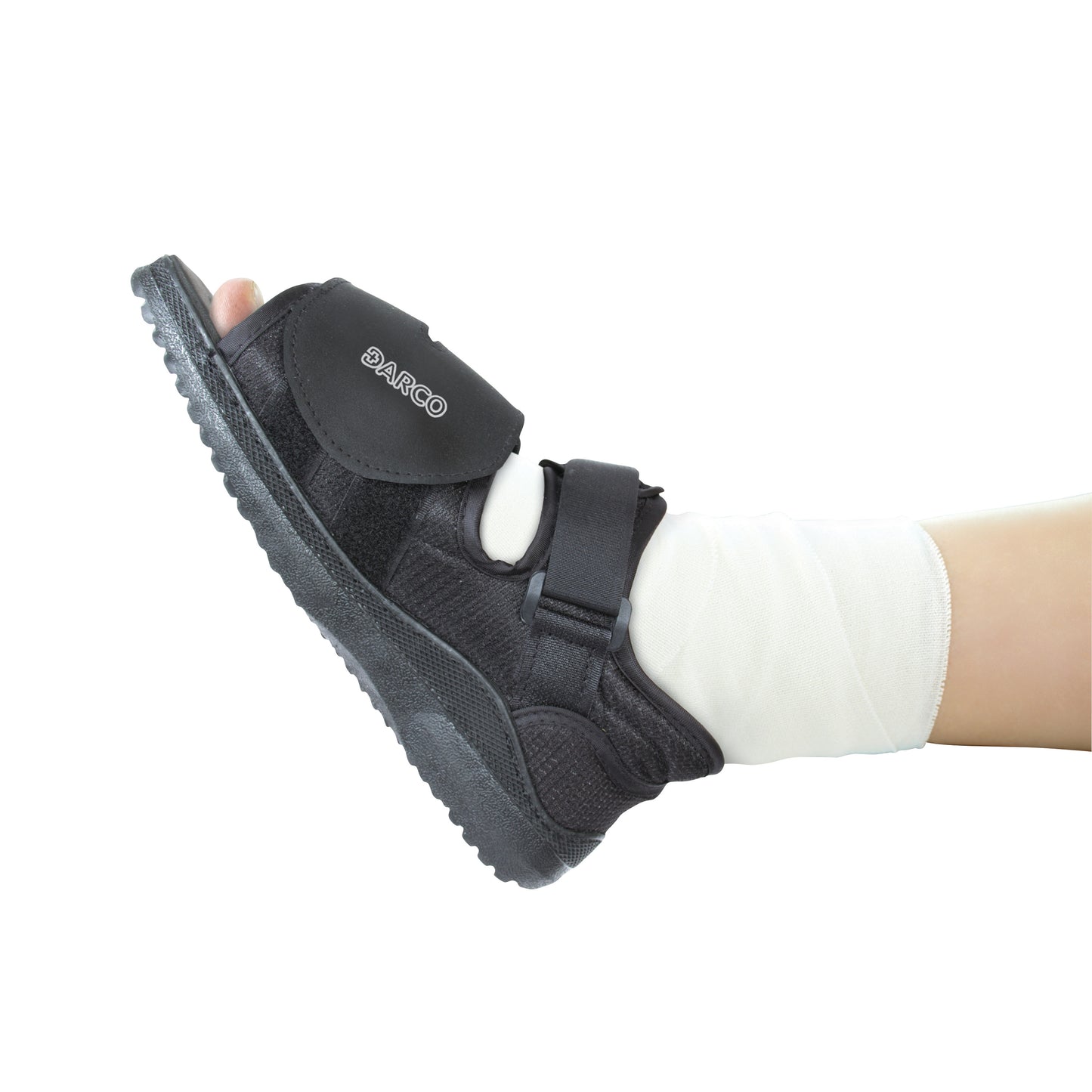 A foot in a DARCO MedSurg Shoe with ankle support, featuring an adjustable strap over a bandaged leg, is shown from the side.