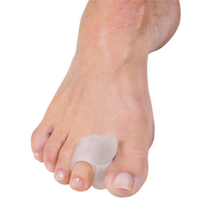 A foot wearing a PediFix Visco-GEL Stay-Put Toe Spacer between the big and second toe for alignment and comfort.