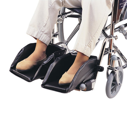 Woman's feet rest in SkiL-Care Swing-Away Foot Support on a wheelchair, offering padded, adjustable foot positioning.