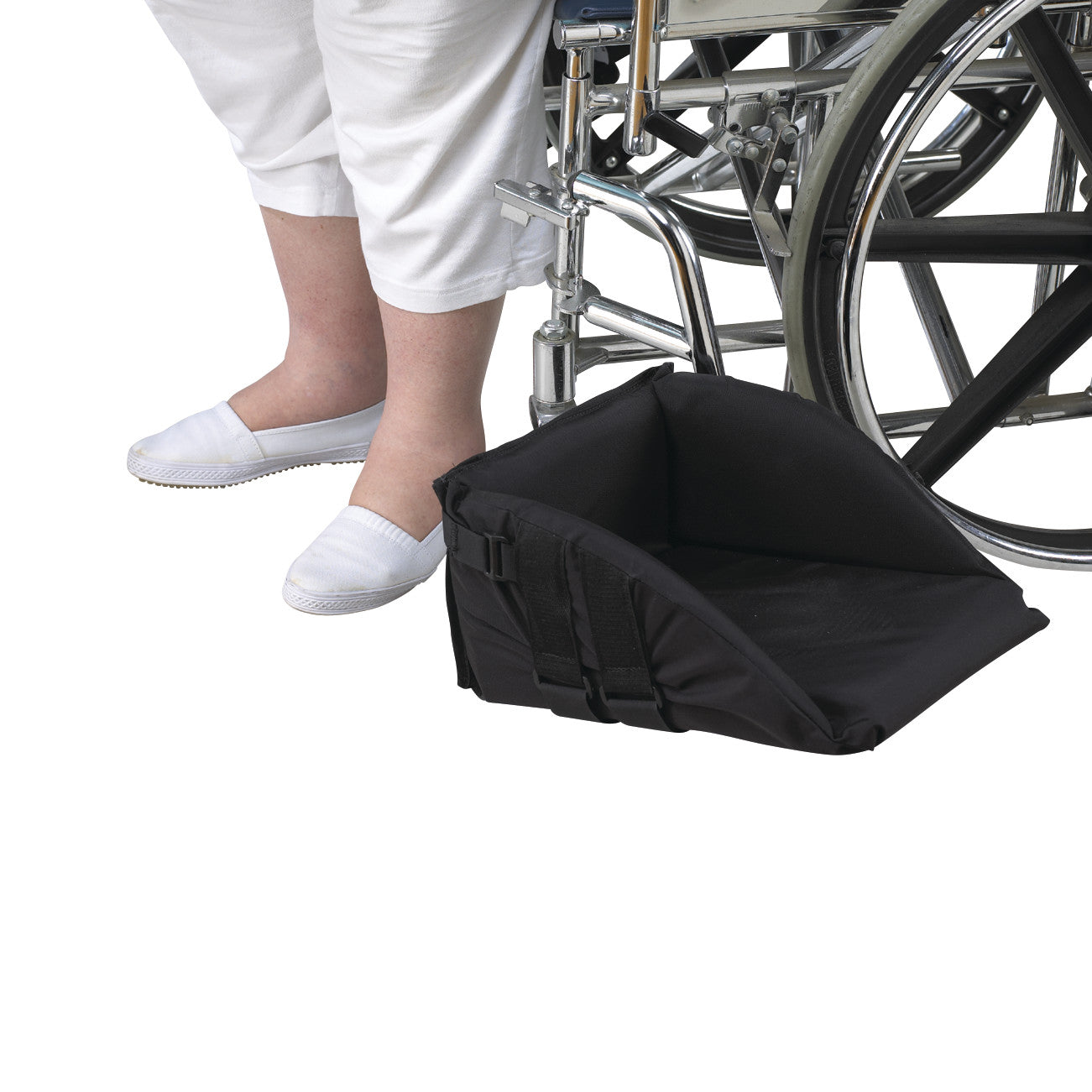 A person sits in a wheelchair using a SkiL-Care Swing-Away Foot Support, which is positioned to assist foot comfort.