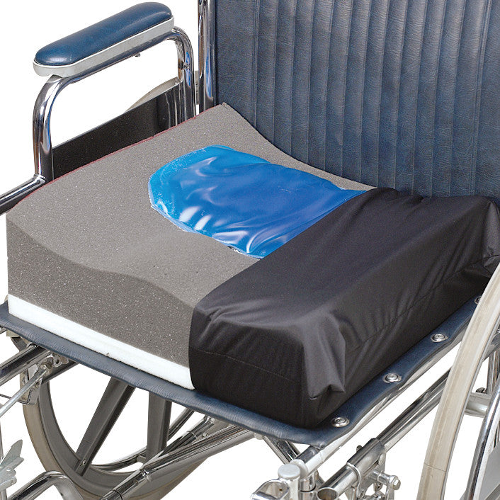A Wheelchair Cushion with a blue gel insert is placed on a wheelchair, featuring a black cover and layered foam design.