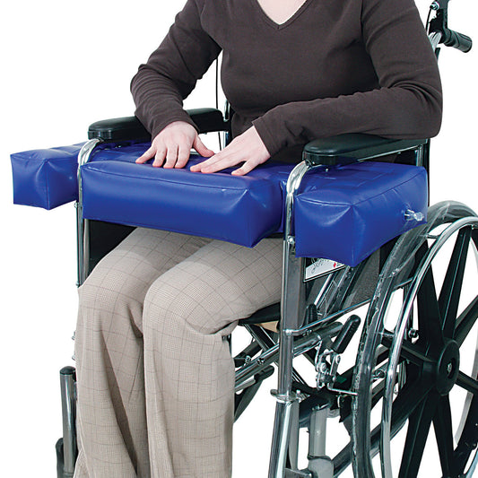 Person in a wheelchair using the AliMed Inflatable Lap Buddy in blue, providing arm support and comfort.