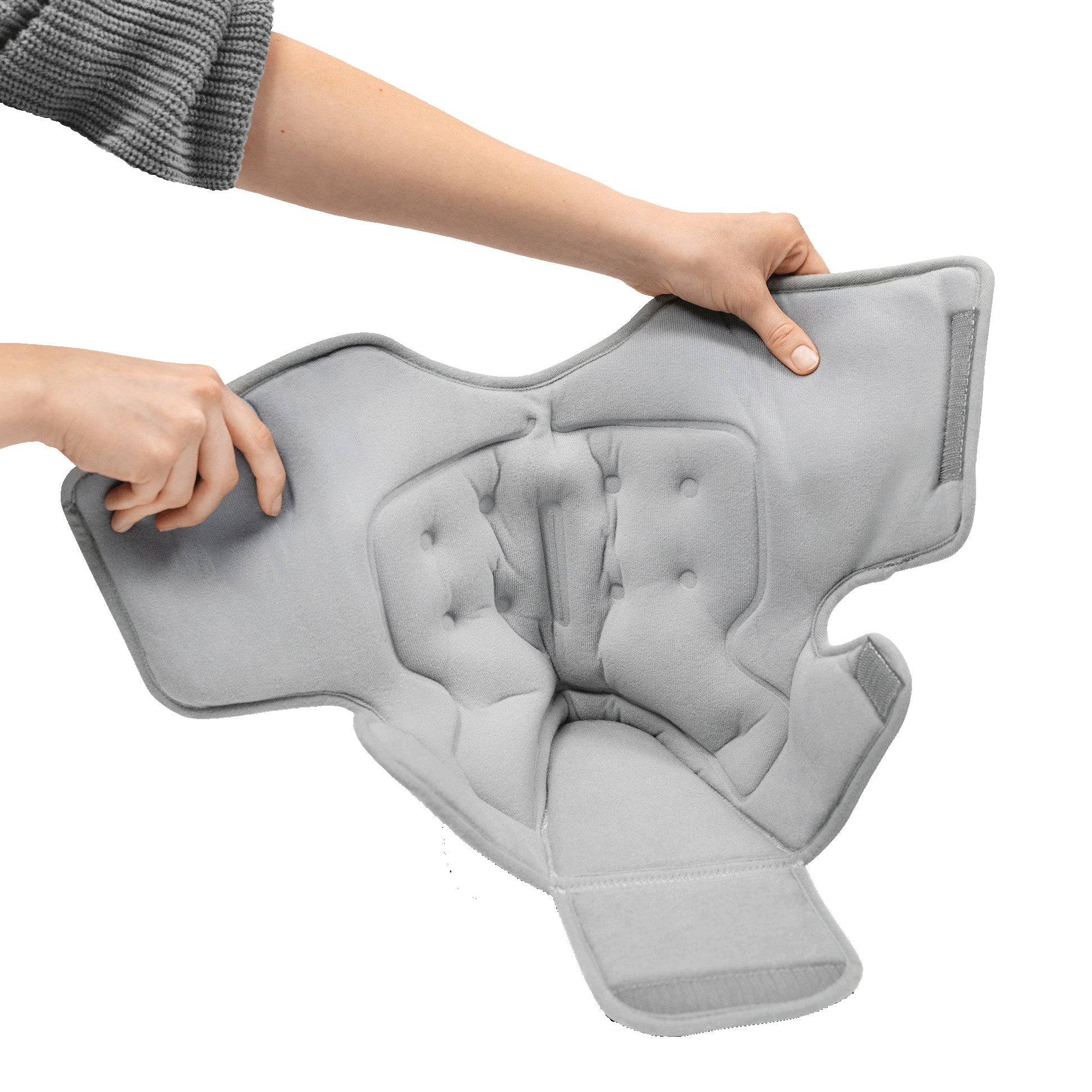 Two hands hold the padding insert for the DARCO Body Armor PFA Walker, showing its soft, contoured design with fasteners.