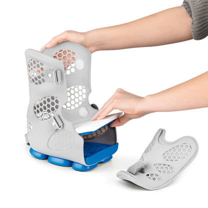 A person adjusts the DARCO Body Armor PFA Walker, featuring a gray, ventilated design with blue soles, inserting a white insole.