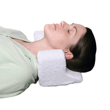 A woman rests with eyes closed, using the AliMed Cervical Neck Pillow, providing support to her neck and head.