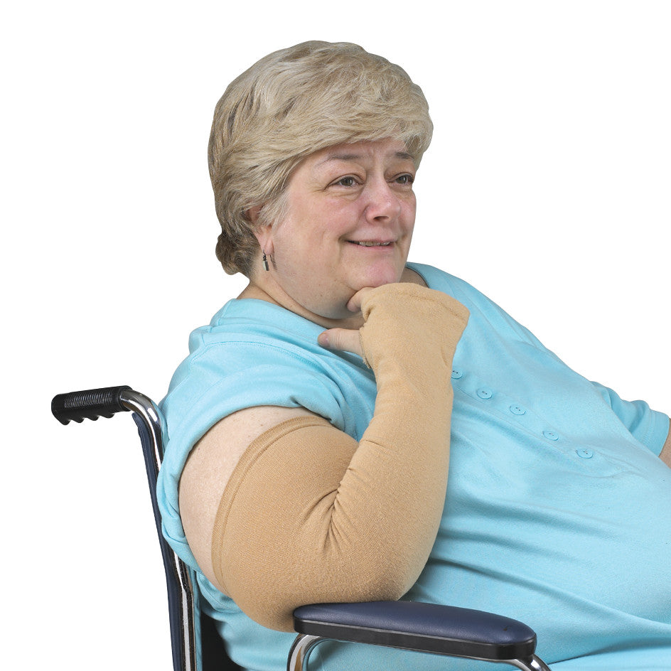 An older adult in a wheelchair wears a SkiL-Care Geri-Sleeve on their arm, designed for compression and skin protection.