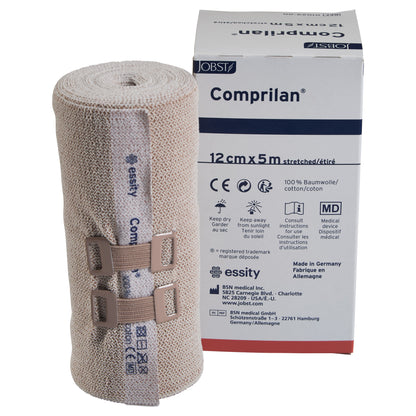 BSN Comprilan Bandage, 12cm x 5m, is shown with its packaging. The bandage is rolled and secured with beige clips.