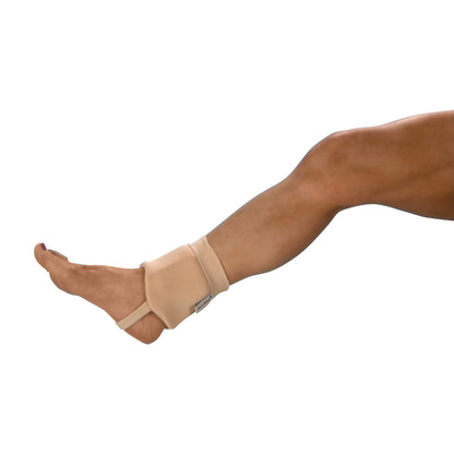 A leg wearing a beige DermaSaver Ankle Bumper with a strap, covering the ankle and part of the foot, against a plain background.