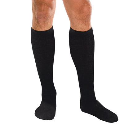 Person wearing Core-Spun by Therafirm Support Socks, which are black and knee-high, against a white background.