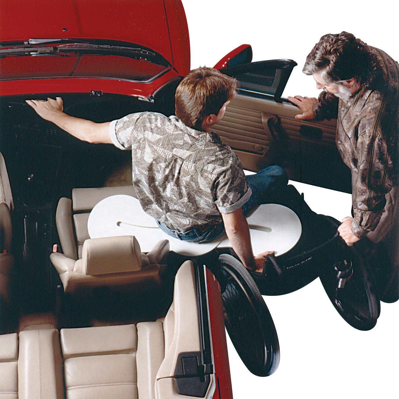 A man uses the BeasyTrans Easy Transfer System to move from a wheelchair into a car, with assistance from another person.
