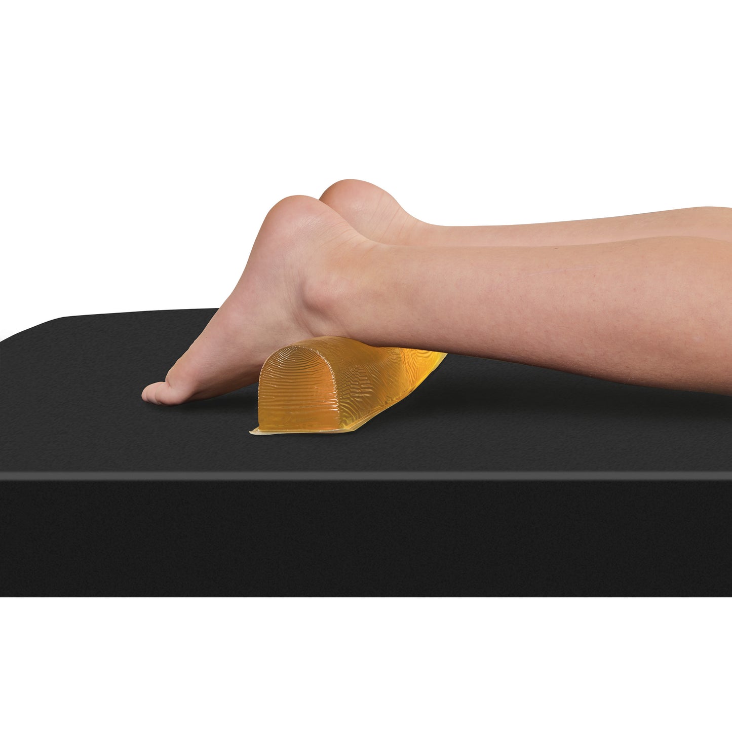 A pair of feet rests on an AliMed AliGel Chest Roll, a cylindrical gel cushion on a black surface, used for support and comfort.