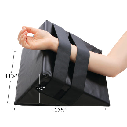 An arm rests on the AliMed Hand and Limb Prepper with 13.5\"x11.5\"x7.75\" dimensions, secured by two wide black straps.