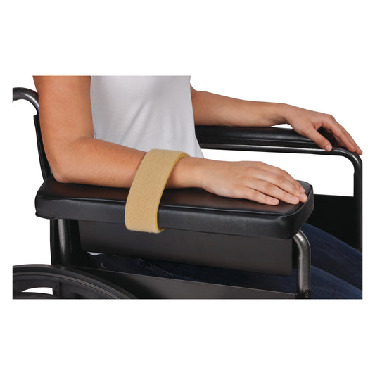 A person rests their arm on a wheelchair armrest, secured with an AliMed Super Beta Pile II Loop in beige for support.