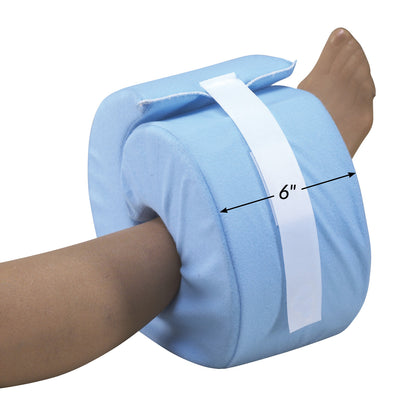 A foot is placed inside a blue SkiL-Care Foot/Heel Elevator with a white strap. The elevator is labeled as 6 inches in width.