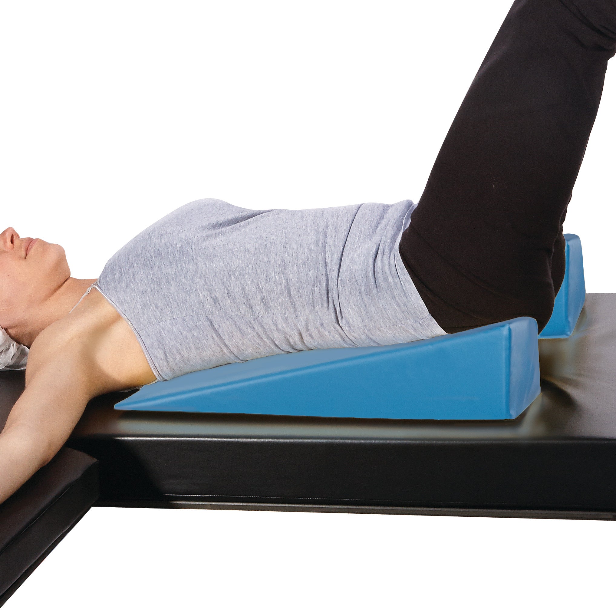 A person lies back with their legs raised on an AliMed U-Shaped Perineal/Endovaginal Wedge, designed for medical positioning.