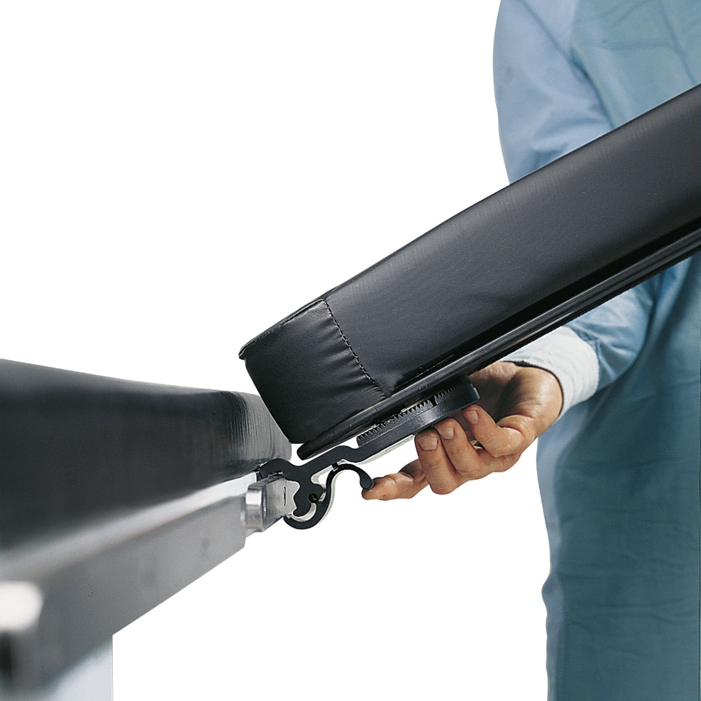 A person adjusts an Allen Lift-to-Position Easy Armboard attached to an EU surgical table side rail, wearing a blue medical gown.