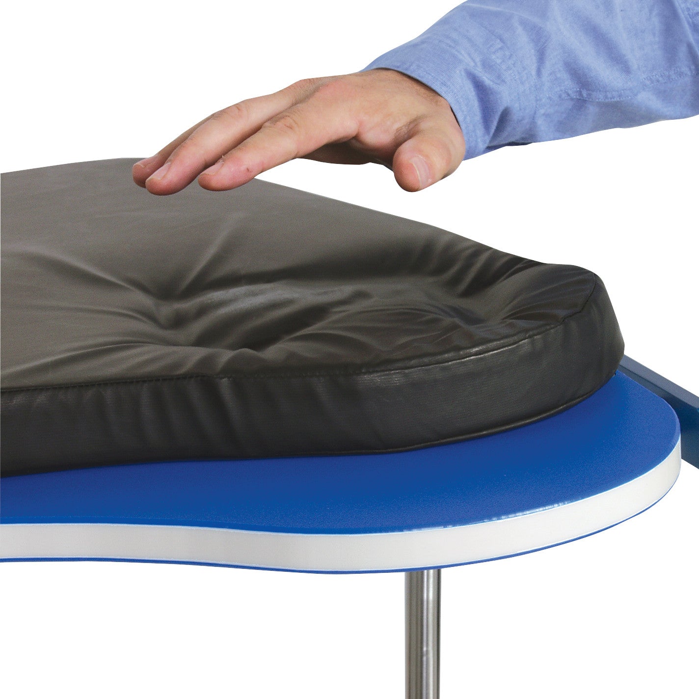 A hand touches the Replacement Pad for AliMed Hourglass Hand Table, showing its softness, on a blue and white table surface.