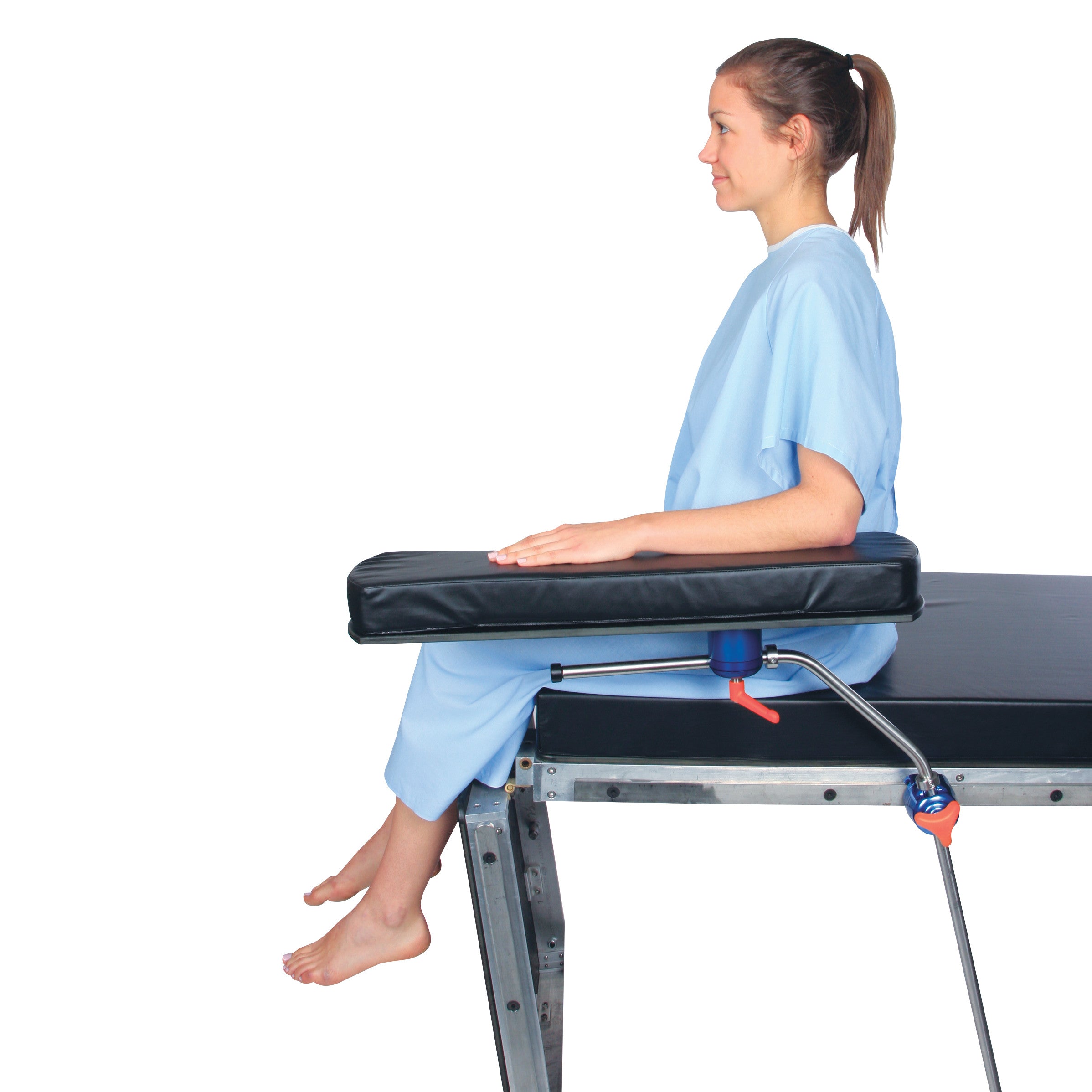 A person sits on a table with their arm resting on an AliMed Versa-Board, a padded support for comfort and stability.